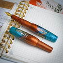 BENU Pixie Aurora Gold Fountain Pen - Two Pens On Top of Notebook | EndlessPens
