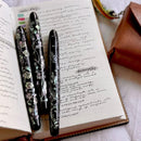 Three CYPRESS × @micahfinds Victorian Flora: The Humble Fern Fountain Pens On Top Of Notebook | EndlessPens