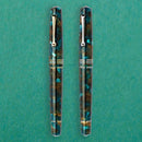 Leonardo Momento Zero 2026 Pausilya Fountain Pen (14K Gold) - Two Fountain Pens in Green Background | EndlessPens