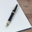 Sailor 1911L Casual Stable Fountain Pen - Muted Black with Nib Exposed on Top of Paper | EndlessPens