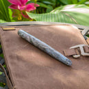 Tailored Pen Company × @micahfinds Labradorite Fountain Pen on Top of Leather Bag | EndlessPens